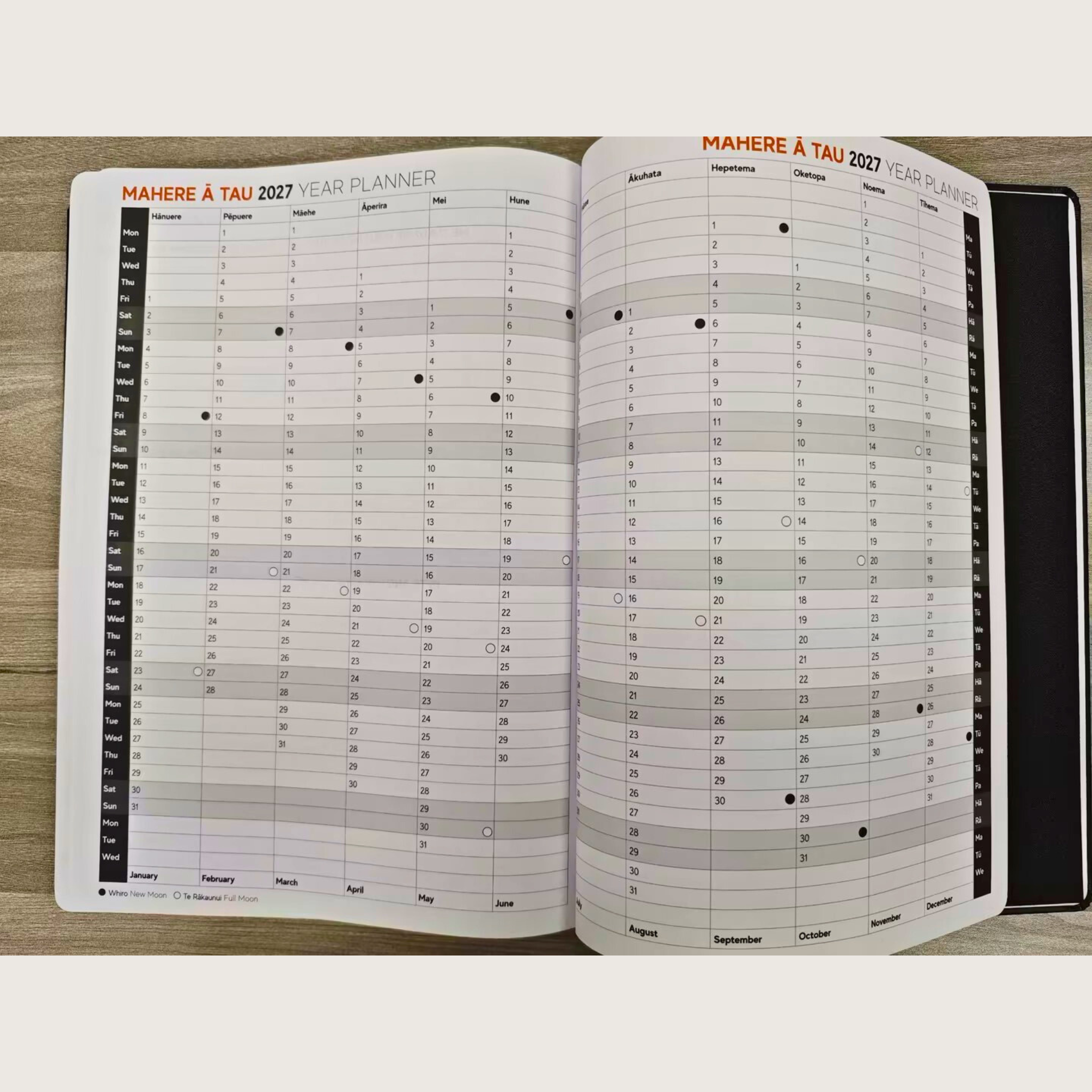 Open year planner with calendar pages on a wooden surface